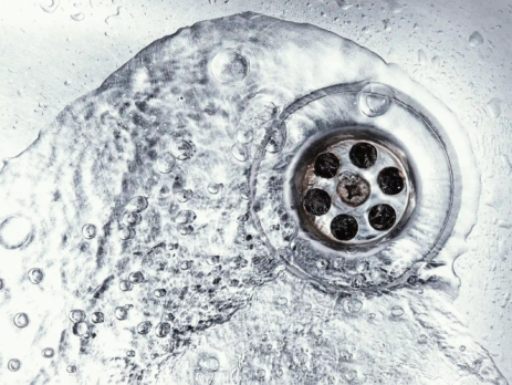 Sink plughole with water pouring down it
