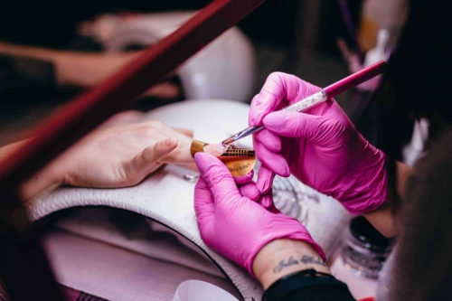 Someone removing acrylic nails with acetone