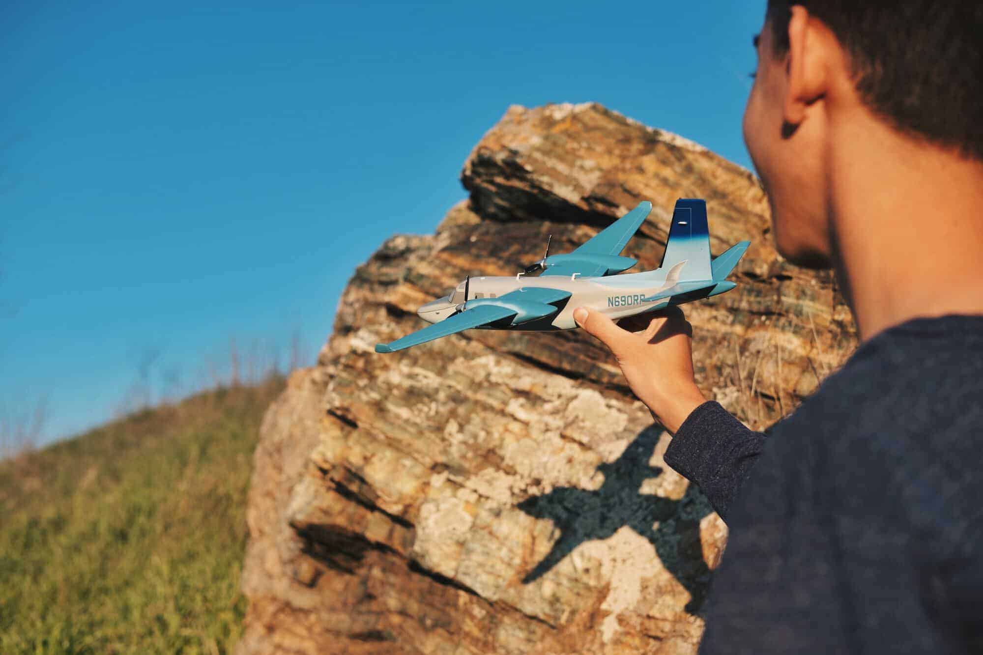 Person holding a blue model aeroplane