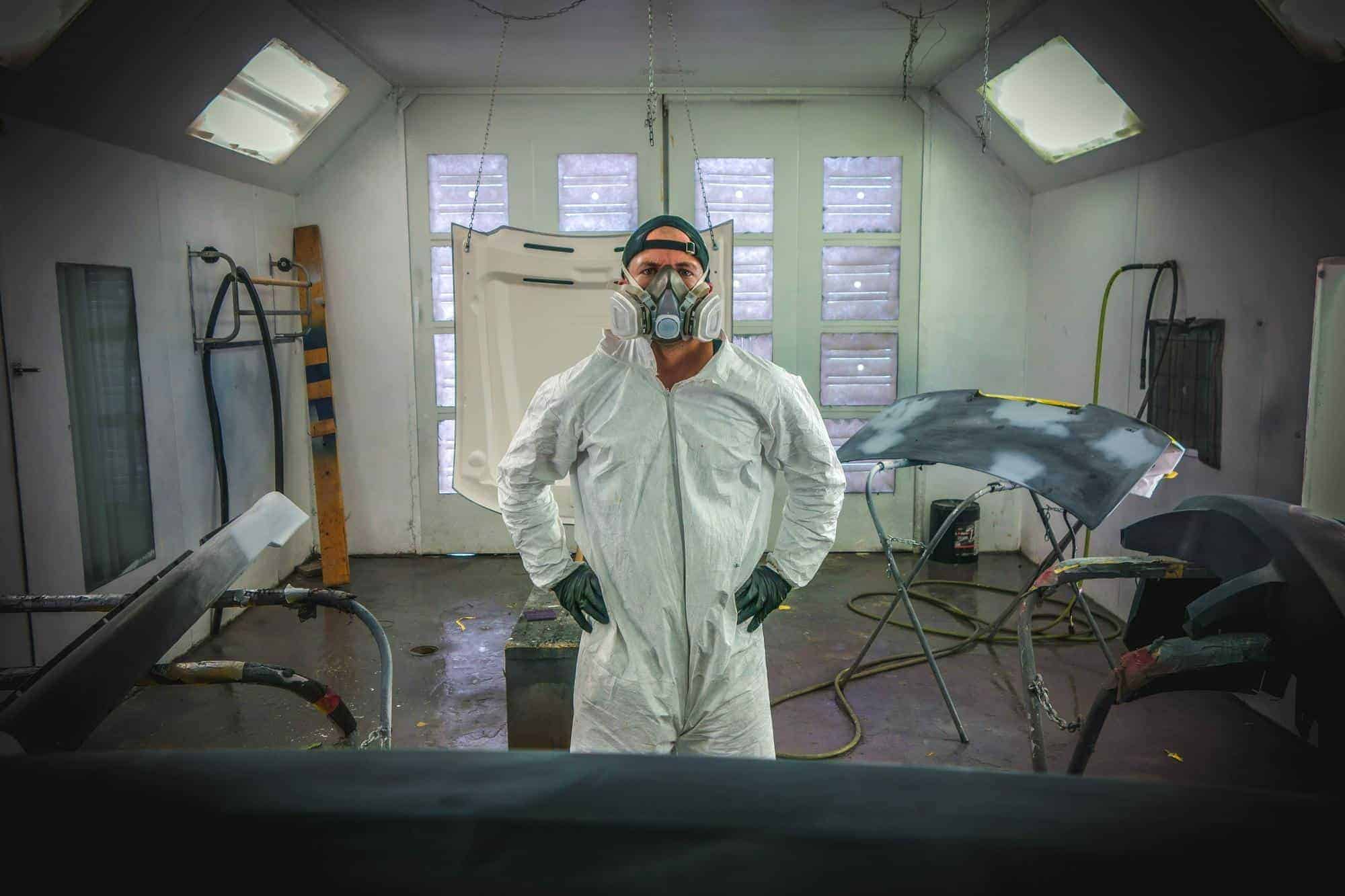 Man wearing protective clothing and a filtration mask