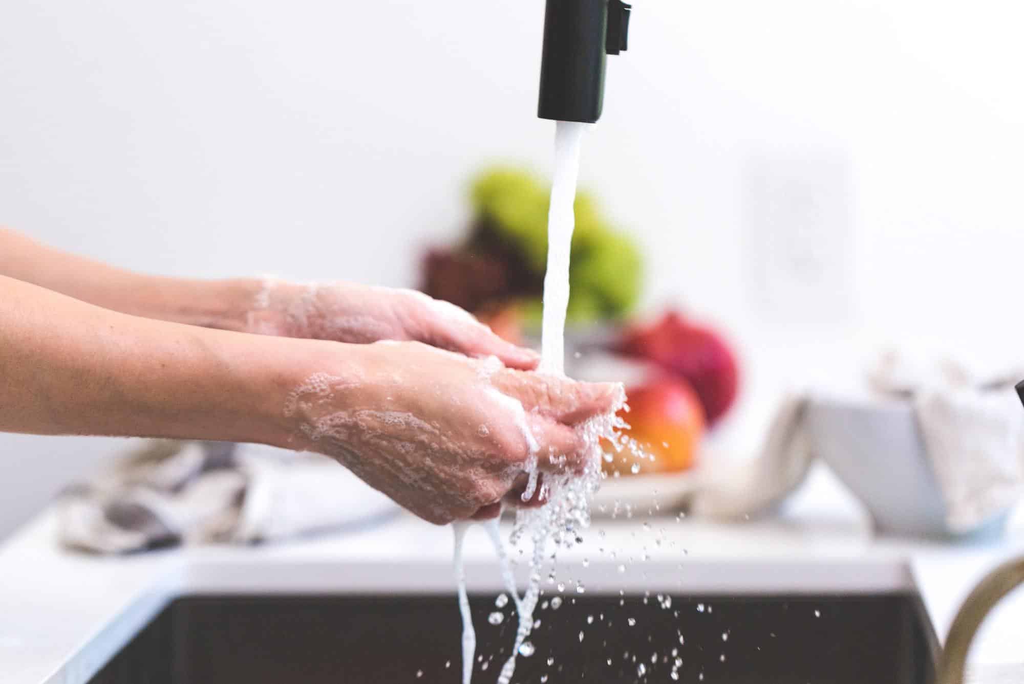 Person washing their hands under a black tap