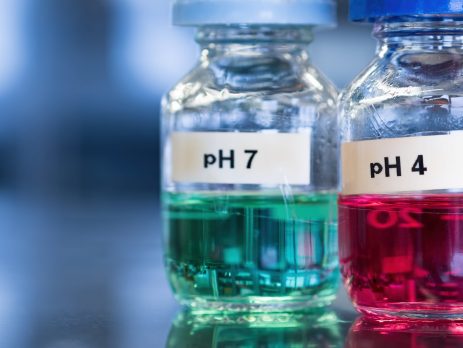 Two vials containing green and pink liquid