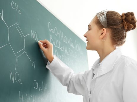 Chemistry student writing on a blackboard