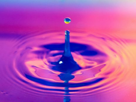A droplet of water in a colourful pool of water