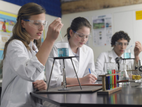 Teenage students caring out experiments in chemistry GCSE class