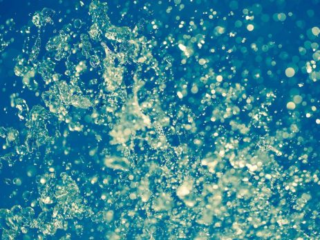 A large splash of water with a green and blue colour overlay