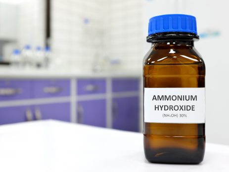 Brown glass bottle of ammonium hydroxide in lab setting