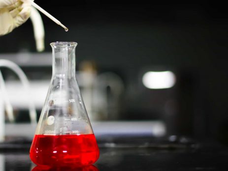 Red chemical in glass conical flask