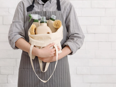 Person holding basket of natural cleaning supplies
