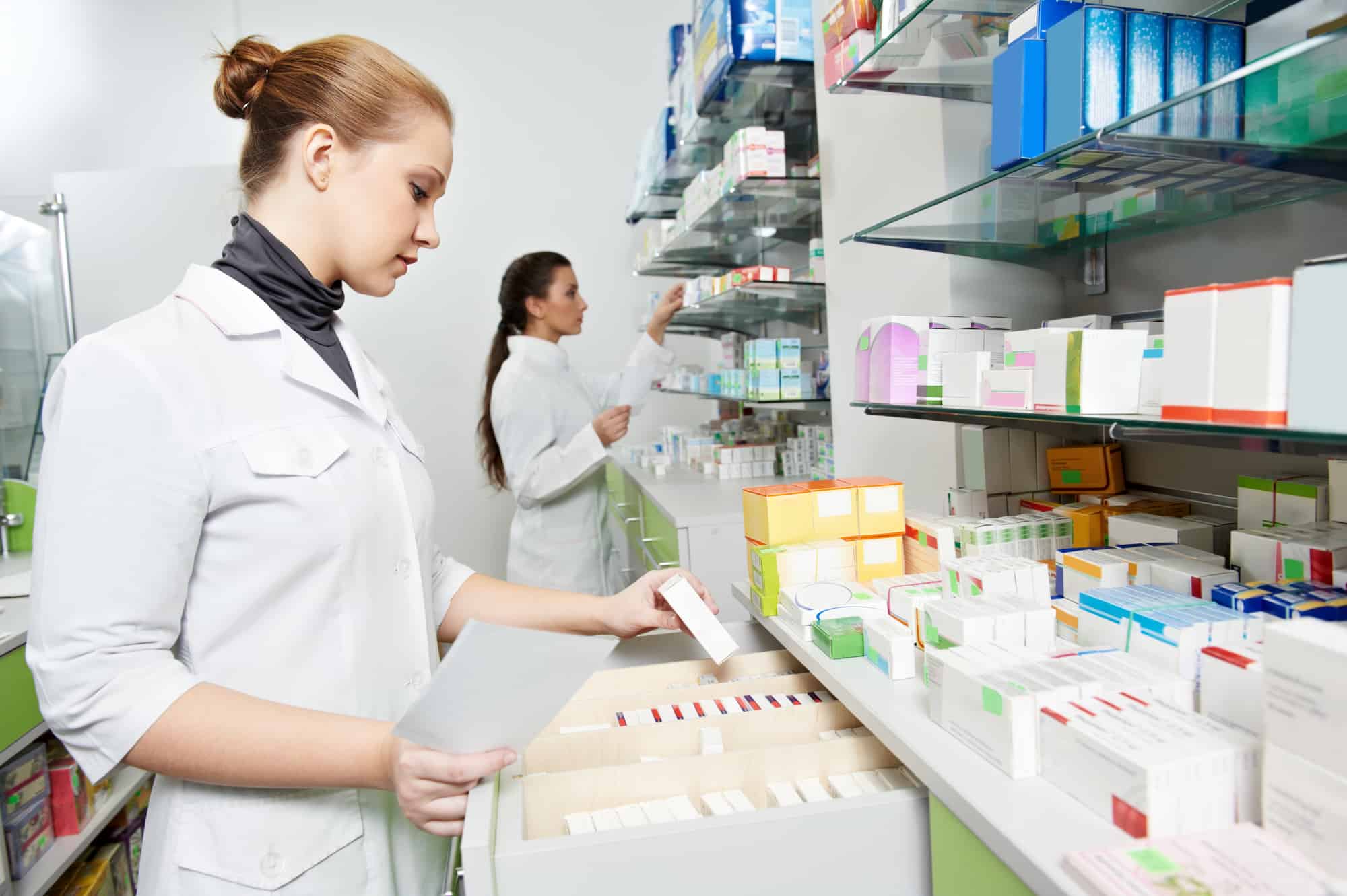 Two pharmacist chemist women working in pharmacy drugstore