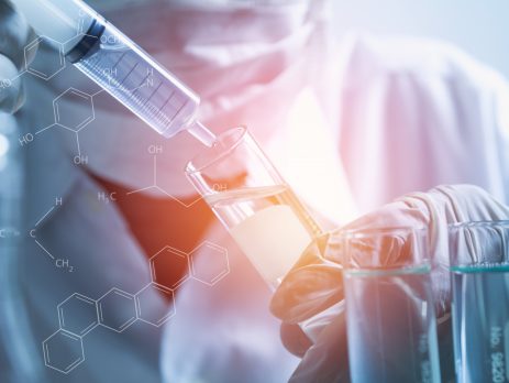 Researcher with glass laboratory chemical test tubes with liquid for analytical purposes