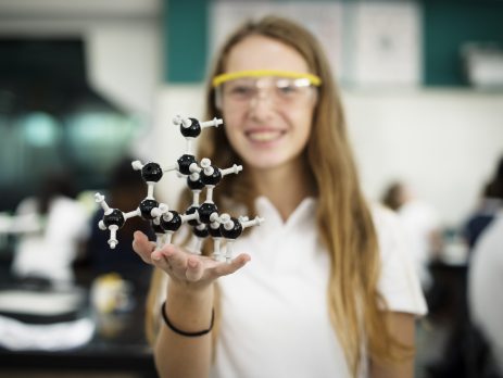GCSE student hand holding molecule structure in chemistry class