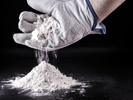 Gloved hand holding powdered titanium dioxide