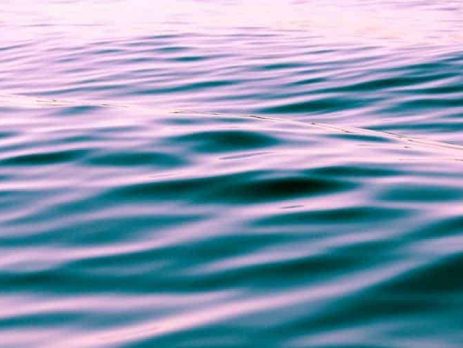 Waves of water in the ocean, covered by sunset