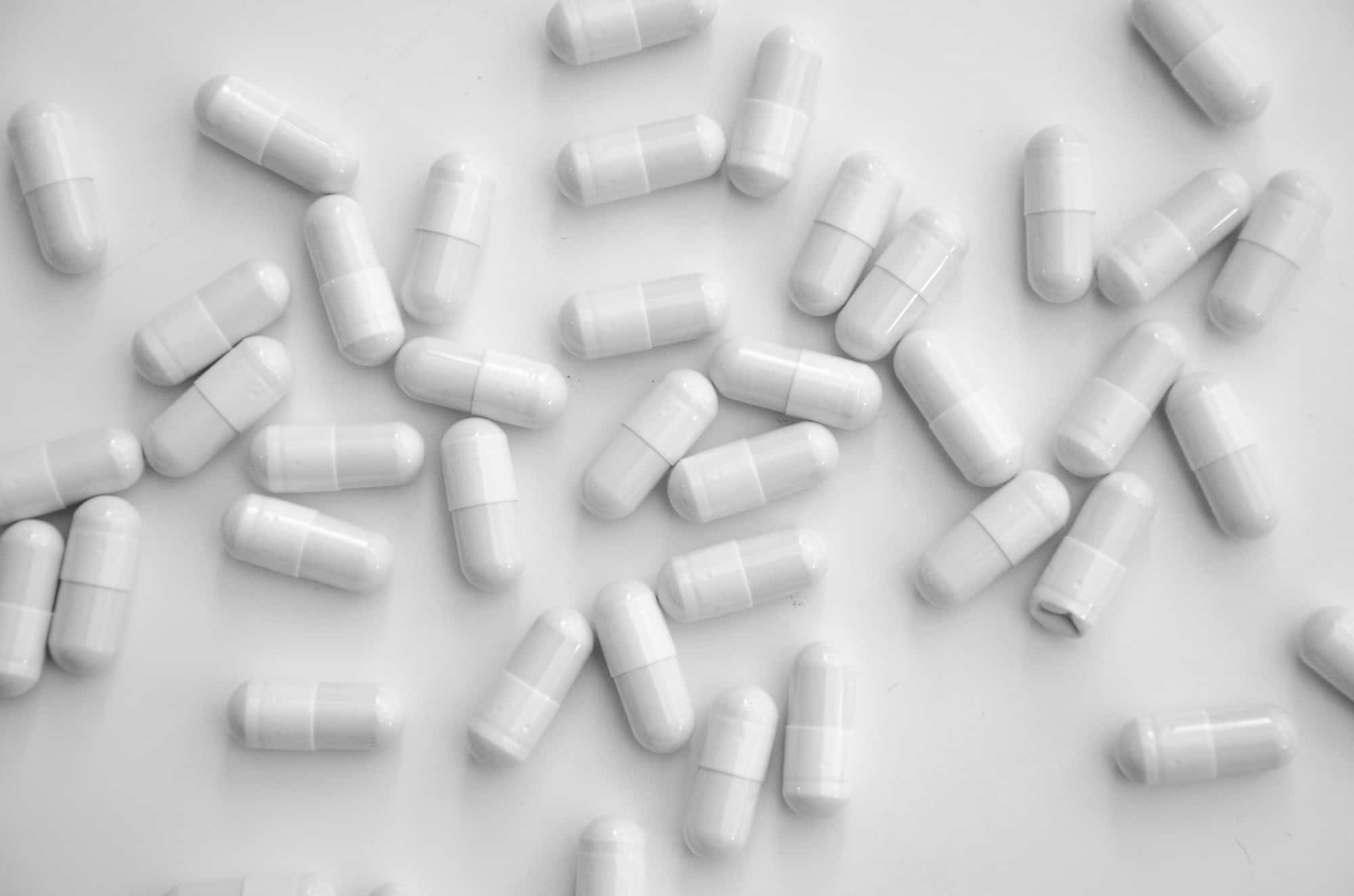 white capsule pills on a white table