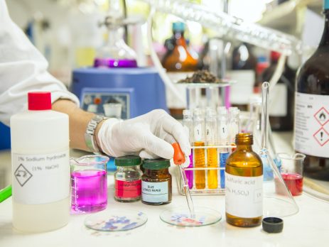 A scientist investigating the acidity or alkalinity of a chemical using litmus paper.