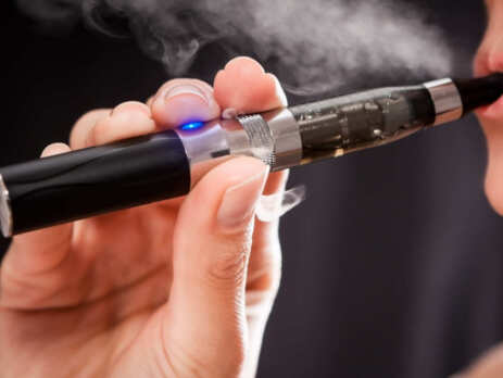 Close up of a woman inhaling from an e-cigarette