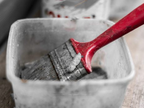 Used paintbrush in a plastic tub of white spirit