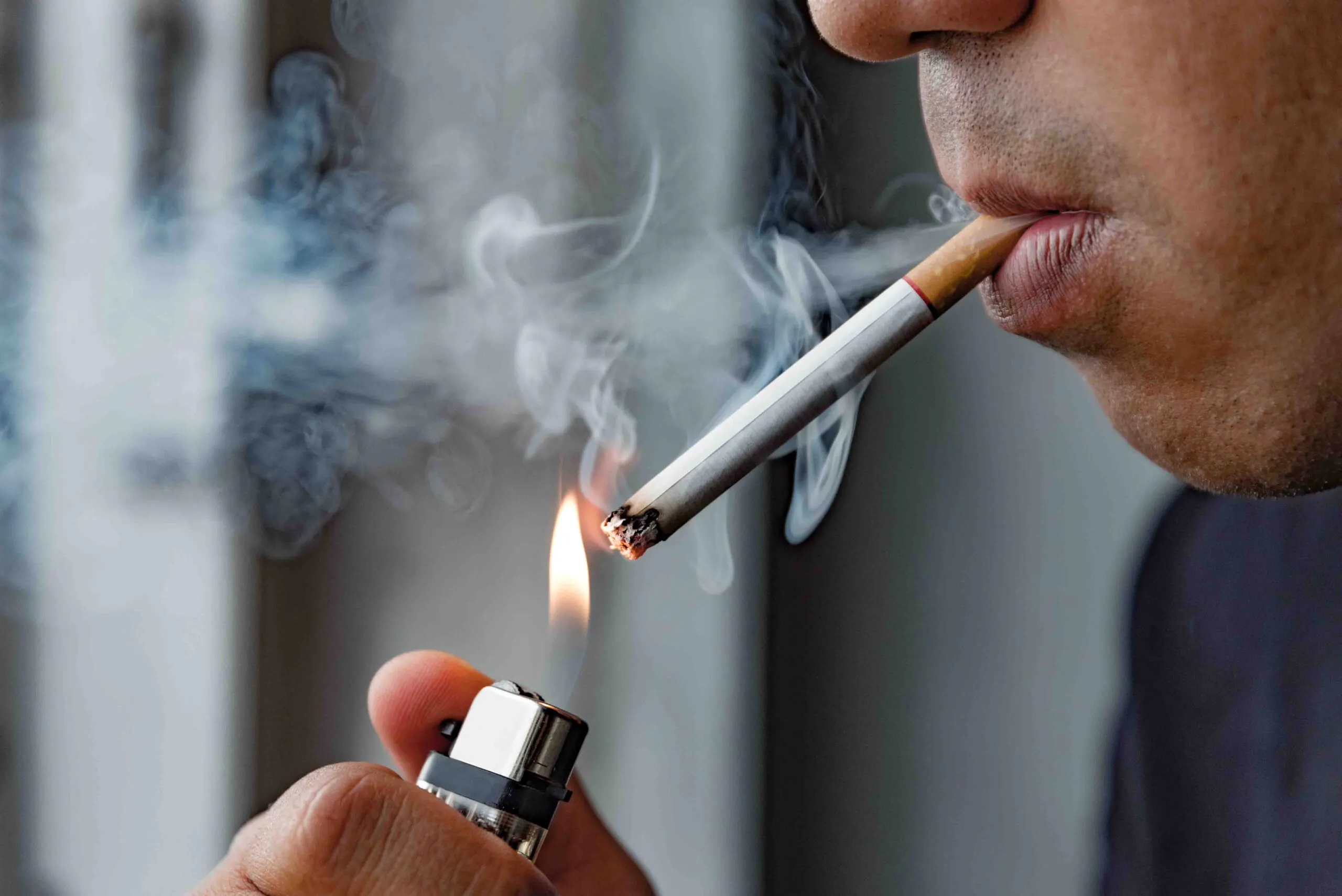 Close up of man lighting a cigarette