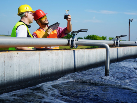 Two engineers checking the quality of water at a wastewater treatment plant