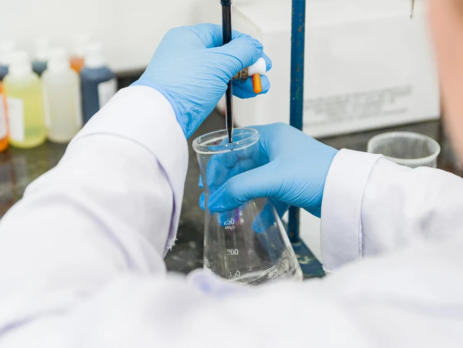 Scientist performing titration test on chemical quality control in a lab