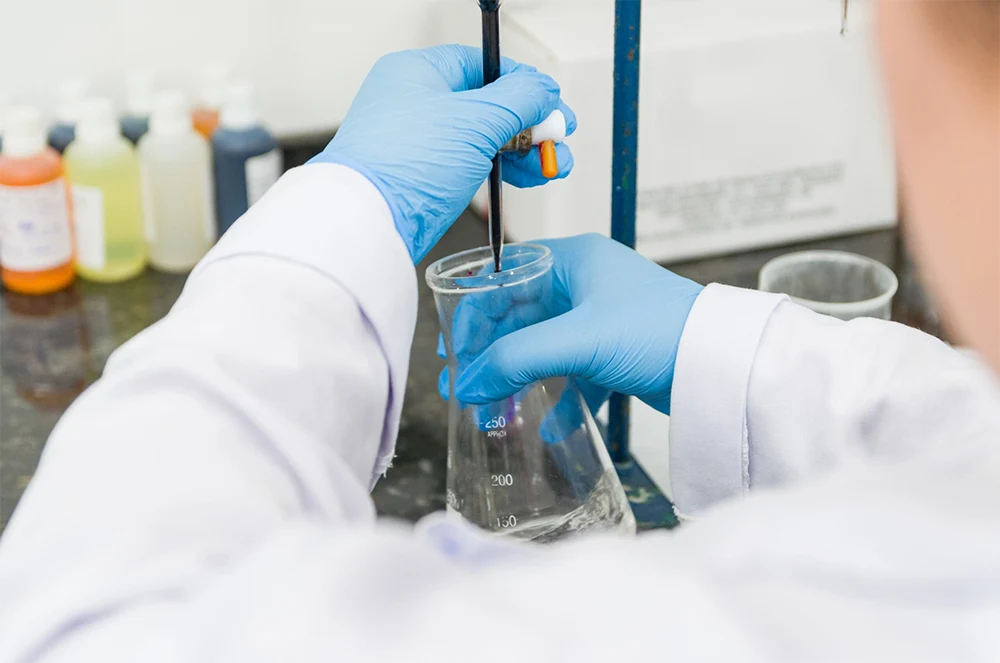 Scientist performing titration test on chemical quality control in a lab