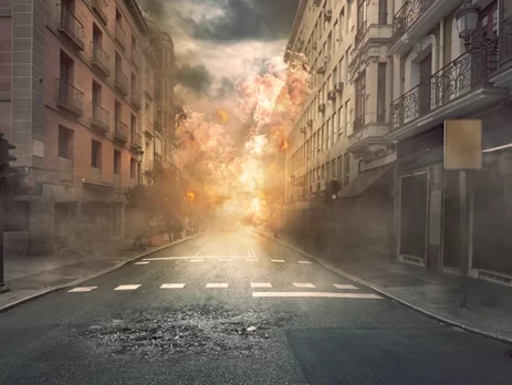 Buildings exploding at the end of a street in a city