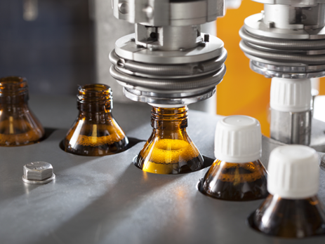 Brown medicine bottles being filled on a pharmaceutical production line