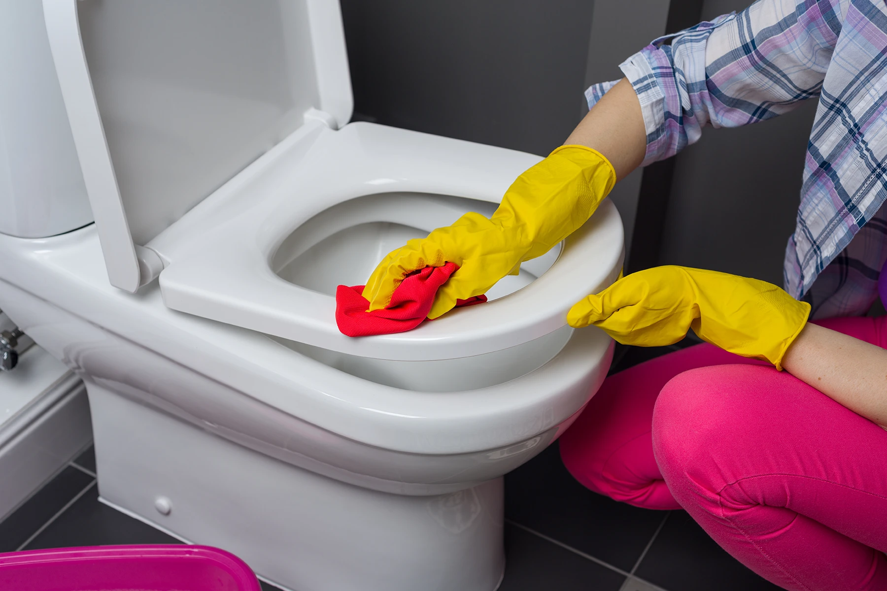 Person cleaning bathroom toilet