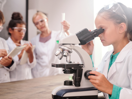 Girl using microscope during primary school science class