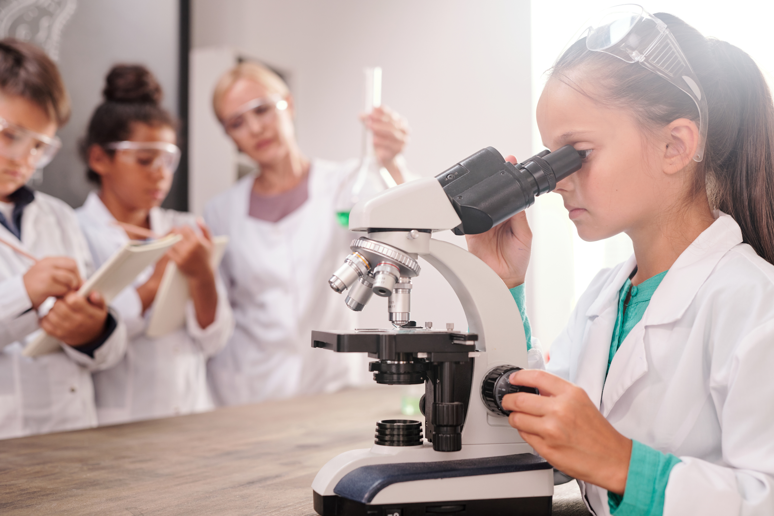 Girl using microscope during primary school science class