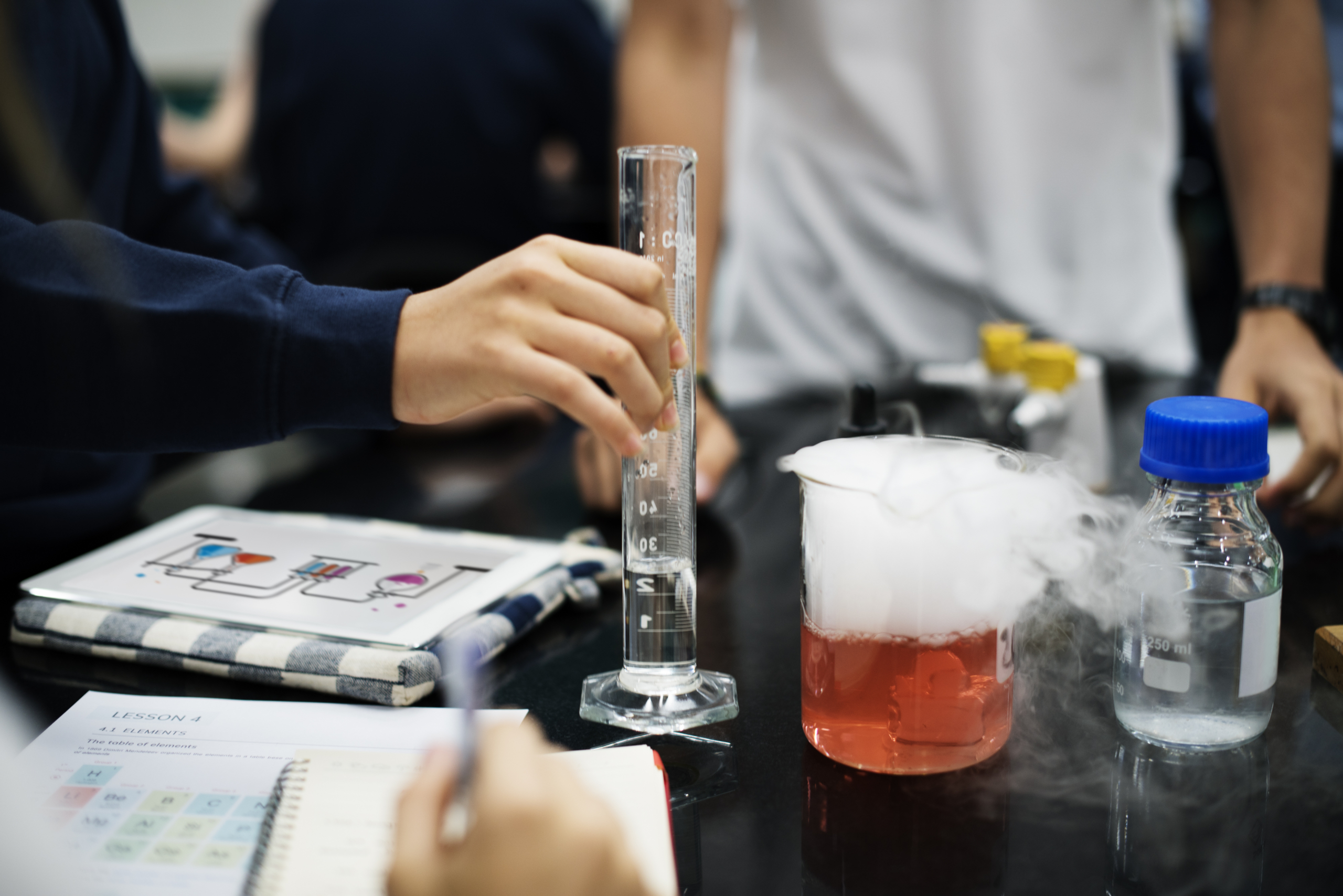 Students performing chemistry experiment with beakers
