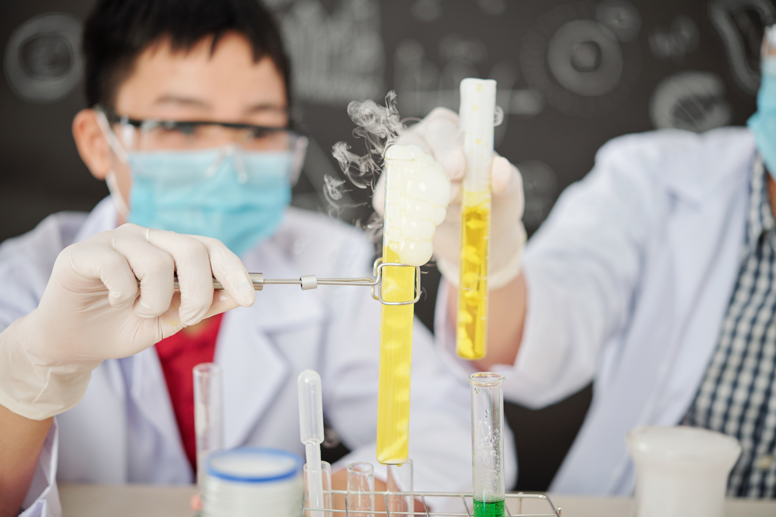 Young boy doing an experiment and following science lab safety rules