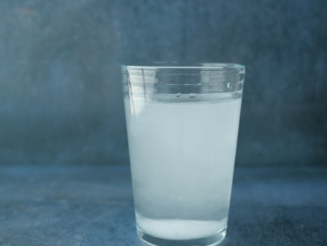 Glass of water with dissolved, cloudy substance in it