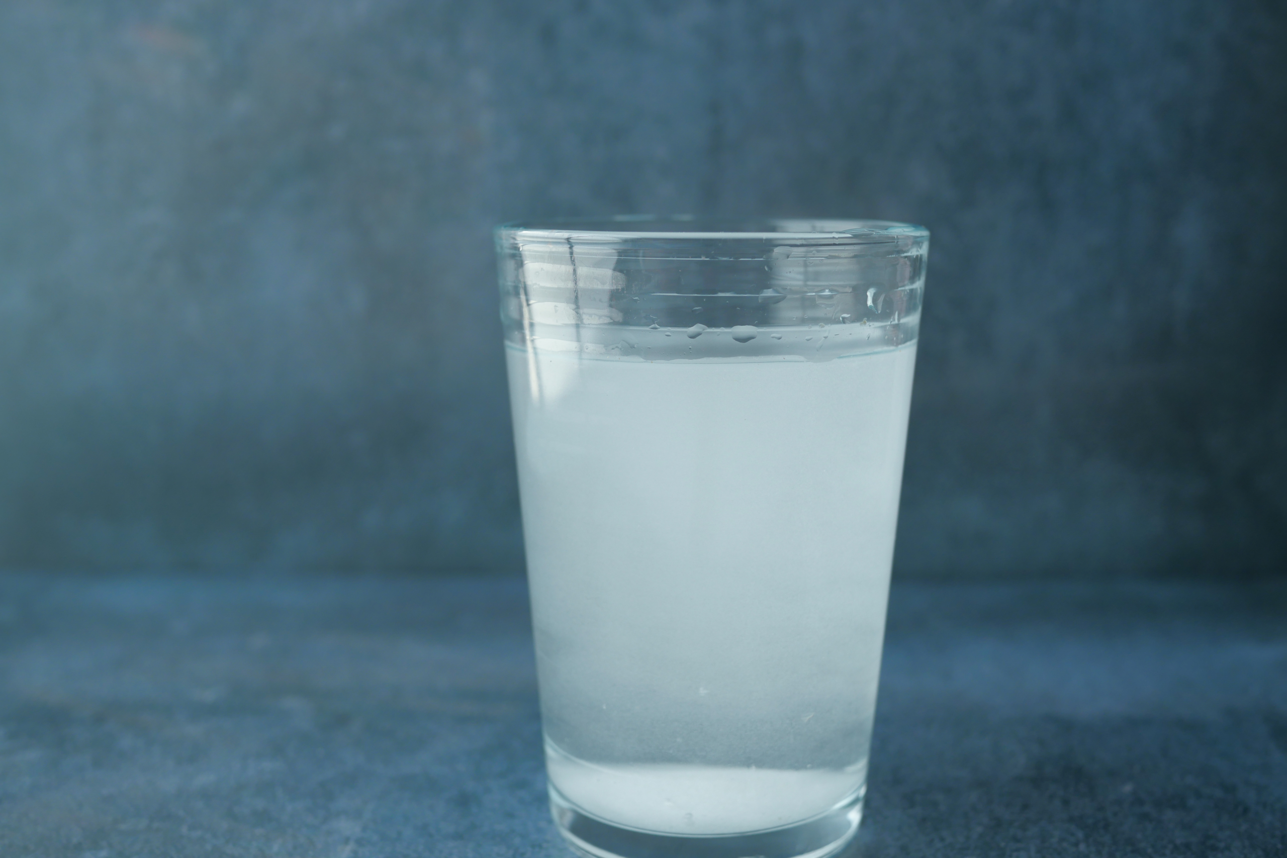 Glass of water with dissolved, cloudy substance in it